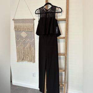 Black NWT wide leg and lace jumpsuit, size small. Zipper back and flutter top